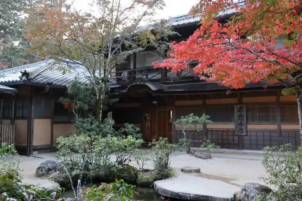 Red and yellow maple leaves over a stream in Momijidani Park, Miyajima.